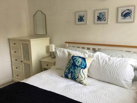 A bedroom with a bed and artwork on the wall at Torpoint Apartment Sleeps4 Seaside Parking in Downderry