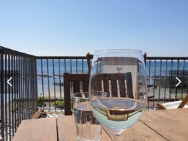 A glass of water and wine glass on a table with ocean view at Torpoint Apartment Sleeps4 Seaside Parking Downderry