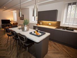 A kitchen with bar stools and countertop at Stunning 3 Bed Converted Village Hall Near Kelso