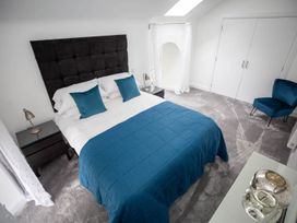 A bedroom with a bed and bedside table at Stunning 3 Bed Converted Village Hall Near Kelso