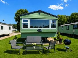 A caravan with seating area and grill at Billing Aquadrome Holiday Park 2bed Caravan Northampton