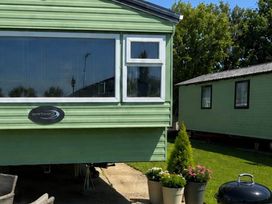 A caravan with plants in pots and grill at Billing Aquadrome Holiday Park 2bed Caravan Northampton