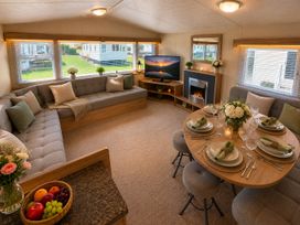 A living room with a sofa, table, and television at Billing Aquadrome Holiday Park 2bed Caravan Northampton