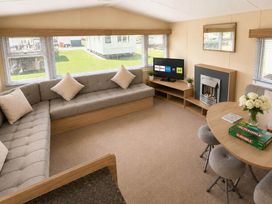 A living room with a sofa and table at Billing Aquadrome Holiday Park 2bed Caravan in Northampton