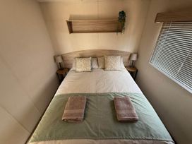 A bedroom with a bed and bedside tables at Billing Aquadrome Holiday Park 2bed Caravan Northampton