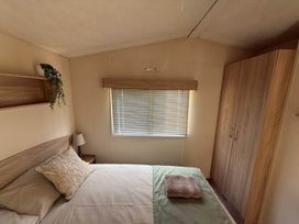 A bedroom with bed and wardrobe at Billing Aquadrome Holiday Park 2bed Caravan Northampton