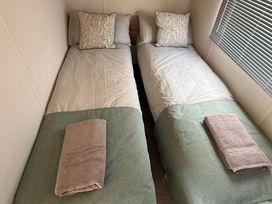 A bedroom with two single beds at Billing Aquadrome Holiday Park 2bed Caravan Northampton