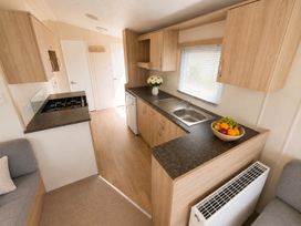 A kitchen with a sink and stove at Billing Aquadrome Holiday Park 2bed Caravan Northampton