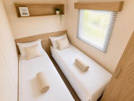 A bedroom with two single beds and a window at Billing Aquadrome Holiday Park 2bed Caravan Northampton