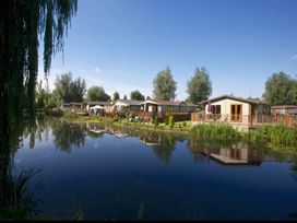 An outdoor area with caravans along a water body at Billing Aquadrome Holiday Park 2bed Caravan Northampton