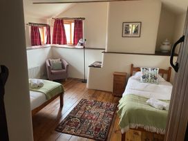 A bedroom with two beds and a chair at The Old Barn in Manchester
