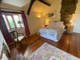 A bedroom with a bed, nightstand, and window at The Old Barn in Manchester