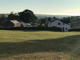 A house and field with tree in the background at a property location