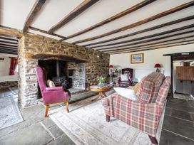A living room with a fireplace and seating arrangements at 16th Century Devon Farmhouse Stunning Views Winkleigh