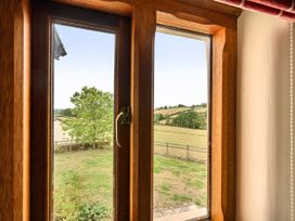 A view from a window showing a tree and open fields at 16th Century Devon Farmhouse Stunning Views Winkleigh