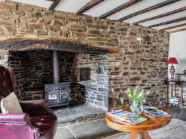 A living room with a fireplace and seating area at 16th Century Devon Farmhouse Stunning Views in Winkleigh