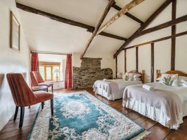 A bedroom with two beds and a chair at 16th Century Devon Farmhouse Stunning Views in Winkleigh