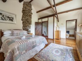 A bedroom with a bed and wooden furniture at 16th Century Devon Farmhouse Stunning Views in Winkleigh