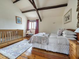 A bedroom with a bed and crib at 16th Century Devon Farmhouse Stunning Views in Winkleigh