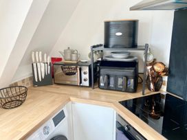 A kitchen with a microwave and utensils at Central Tenby 3 Bed Apt Sleeps 6 to 8 Dog Friendly in Tenby