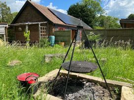 A garden with grill, fire pit and storage containers at Pet Friendly 3Bed Barn Sleeps 7 Parking Garden in Westhall near Halesworth