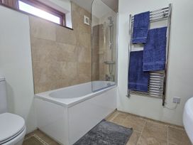 A bathroom with a bath tub and a towel rack at Pet Friendly 3Bed Barn Sleeps 7 Parking Garden Westhall near Halesworth