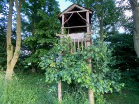 A treehouse with steps and sign in a wooded area at Pet Friendly 3Bed Barn Sleeps 7 Parking Garden Westhall near Halesworth