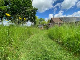 A pathway in a garden with flowers and a barn at Pet Friendly 3Bed Barn Sleeps 7 Parking Garden Westhall near Halesworth