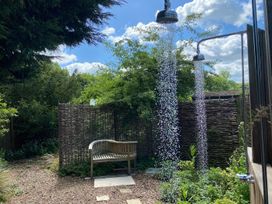 An outdoor shower with a wooden bench in the garden at Pet Friendly 3Bed Barn Sleeps 7 Parking Garden Westhall near Halesworth