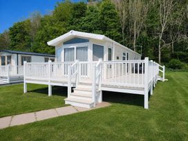 A lodge with a deck and railing at 3 Bed Lodge Sleeps 6 Decking Parking WiFi, Dunbar