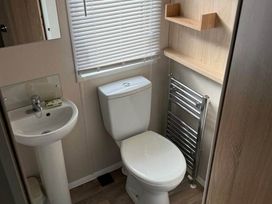 A bathroom with a toilet and sink at 3 Bed Lodge Sleeps 6 Decking Parking WiFi Dunbar