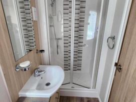 A bathroom with a shower and sink at 3 Bed Lodge Sleeps 6 Decking Parking WiFi Dunbar