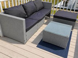 An outdoor seating area with a sofa and coffee table at 3 Bed Lodge Sleeps 6 Decking Parking WiFi, Dunbar