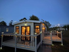 A caravan with a deck and steps at Homely Caravan in Skegness