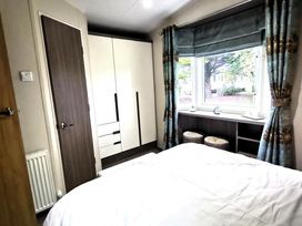 A bedroom with a bed and wardrobe at Homely Caravan in Skegness