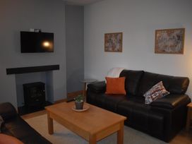 A living room with a sofa, coffee table, and television at Pet friendly Cabin Sleeps 6 with Parking and Garden in Penygroes