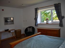 A bedroom with a bed, dressing table, and a chair at Pet friendly Cabin Sleeps 6 with Parking and Garden in Penygroes