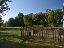 A deck with chairs and a table at Pet friendly Cabin Sleeps 6 with Parking and Garden in Penygroes