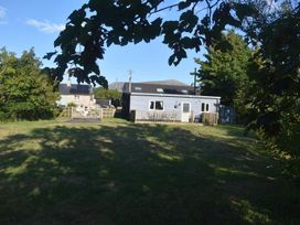 A house with a deck in the garden at Pet friendly Cabin Sleeps 6 with Parking and Garden in Penygroes