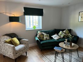 A living room with a sofa, armchair, and coffee table at Yr Hen Beudy Barn Conversion Sleeps 4 Dogs Ok near Brodle Farm near Llansteffan
