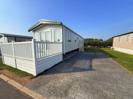 A mobile home with a deck and gravel driveway at 3Bed Sleeps 6 Parking Balcony Flamingo Land Resort near Kirkby Misperton