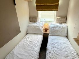A bedroom with two beds and a lamp at 3Bed Sleeps 6 Parking Balcony in Flamingo Land Resort near Kirkby Misperton