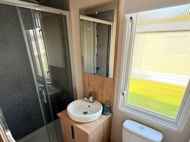 A bathroom with a shower, sink, mirror, and toilet at 3Bed Sleeps 6 Parking Balcony Flamingo Land Resort near Kirkby Misperton