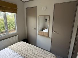 A bedroom with a bed and a mirror at 3Bed Sleeps 6 Parking Balcony in Flamingo Land Resort near Kirkby Misperton