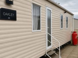 A caravan with a sign named Oakley and a gas cylinder at the entrance
