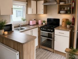A kitchen with a stove, sink, and microwave at the property in unspecified location