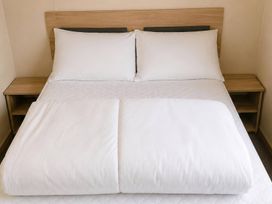 A bed with pillows and a bedside table at the property