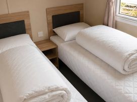 A bedroom with two beds and a bedside table at The Old Barn in Manchester