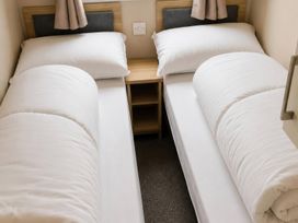 A bedroom with two single beds and a nightstand at 