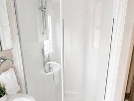 A bathroom with a shower, sink, and towel at an unspecified location